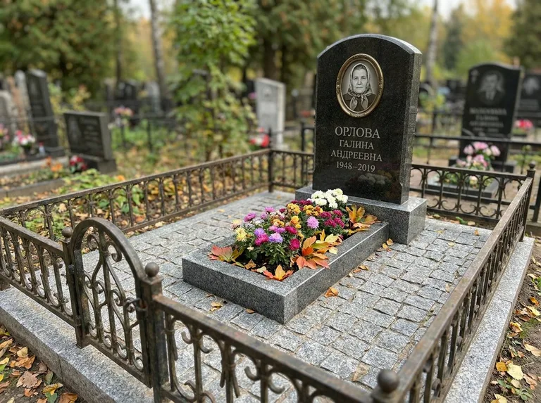 Благоустроенное захоронение с гранитной плиткой, оградой и цветником в Рязани
