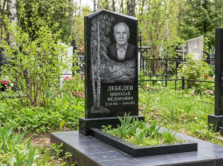 Памятник с гравировкой берёзы: вертикальная стела со скошенным верхом — берёза и стая птиц в небе, гранитный цоколь с тёмной плиткой, работа «Лебедев» в Рязани