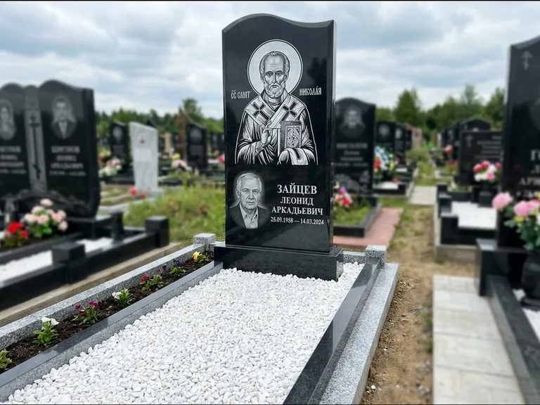 Памятник с гравировкой иконы: стела с крестообразным навершием — икона в резной рамке-киоте, газон без ограды, стриженая трава, работа «Раевская» в Рязани