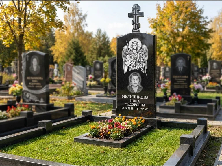 Памятник с гравировкой иконы: округлая стела-медальон с ликом — гравировка Богородицы «Семистрельная», луговые травы и полевые цветы за участком, работа «Гущин» в Рязани