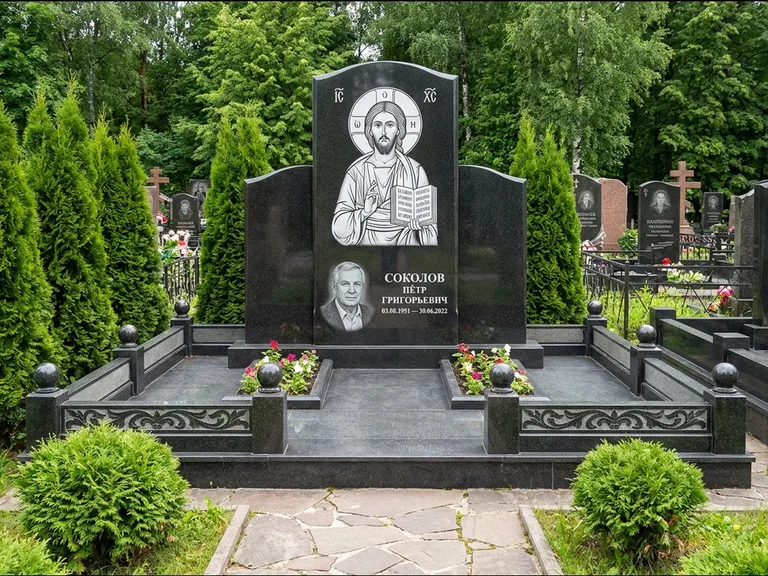 Памятник с гравировкой иконы: широкая горизонтальная лежачая плита-стела — икона в резной рамке-киоте, серая гравийная отсыпка с бордюром, работа «Богданова» в Рязани
