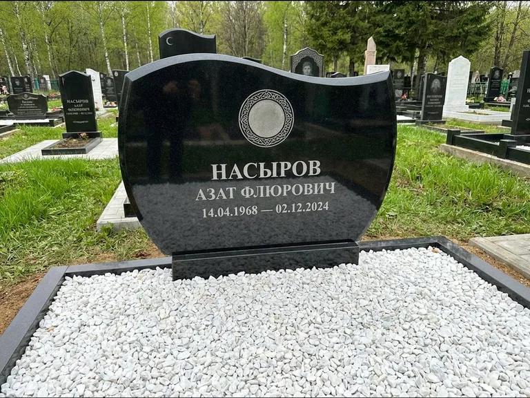 Мусульманский памятник: стела с волнообразным скошенным верхом — гравировка мечети под полумесяцем и звёздами, белая мраморная крошка с бордюром, работа «Насыров» в Рязани