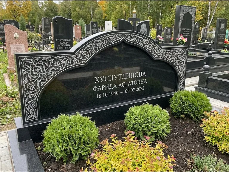 Мусульманский памятник: вытянутая горизонтальная семейная стела с аркой — белая гравировка силуэта мечети с минаретами, участок с декоративными кустами, работа «Зарипова» в Рязани