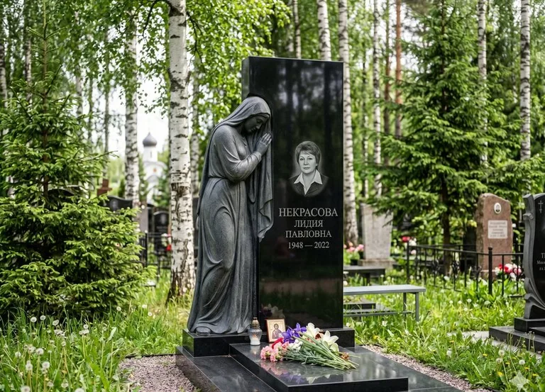 Гранитная фигура скорбящего мужчины у чёрной стелы в Рязани
