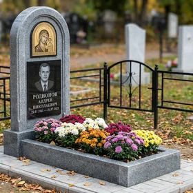 Гранитный памятник в виде скалы с оградой