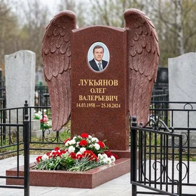 Гранитный памятник в виде сердца с гравировкой скорбящей Богородицы